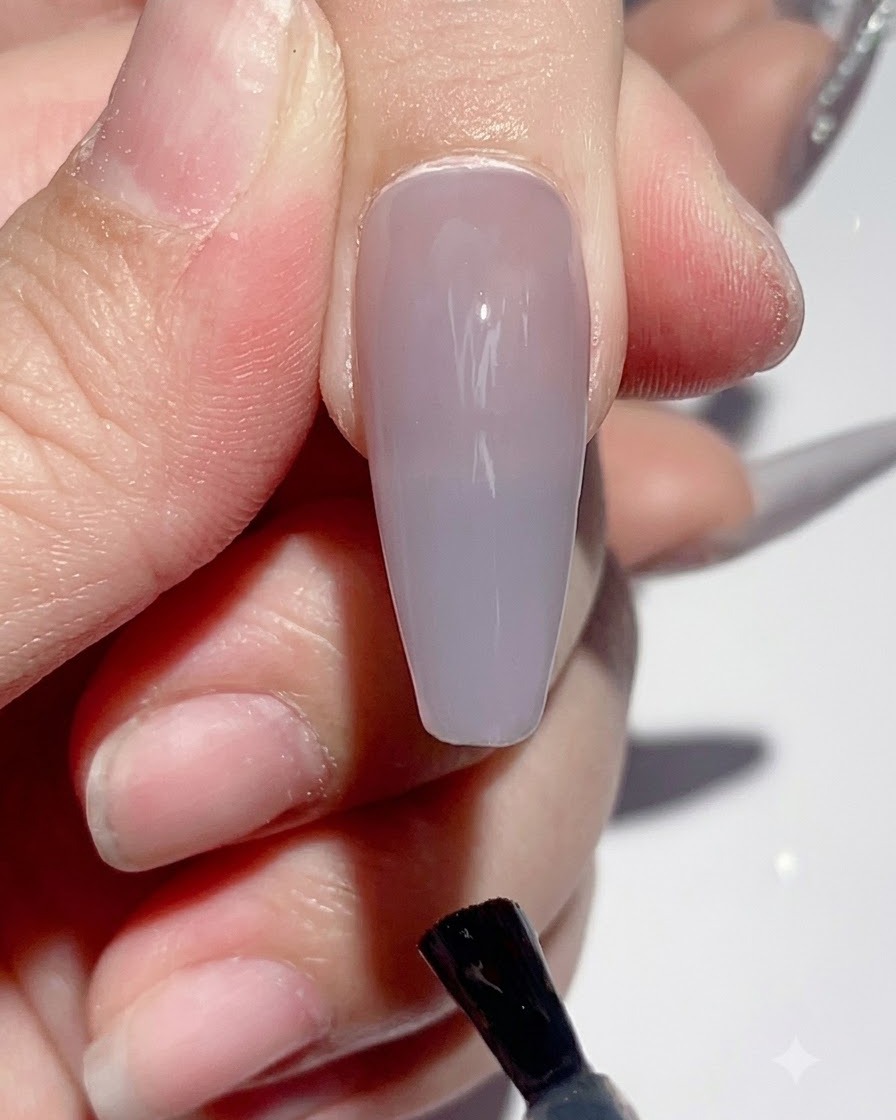 Dłoń umieszczona pod lampą UV LED do paznokci podczas procesu utwardzania.