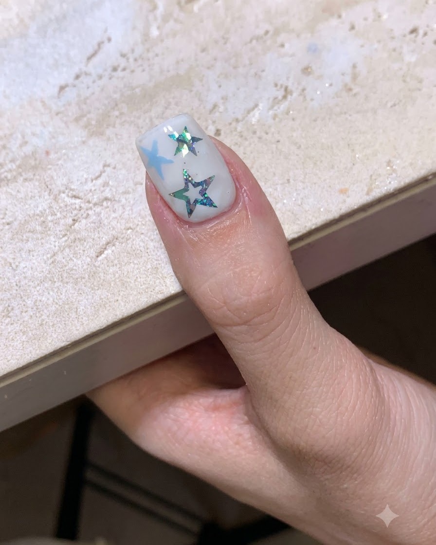 Wykonany manicure z motywem gwiazd utwardzający się pod lampą do paznokci.