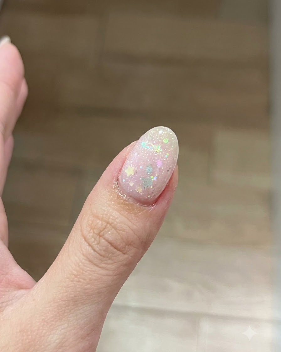 Ein Pinsel trägt eine dünne, klare Schicht Base-Gel auf die Oberfläche eines vorbereiteten Fingernagels auf.