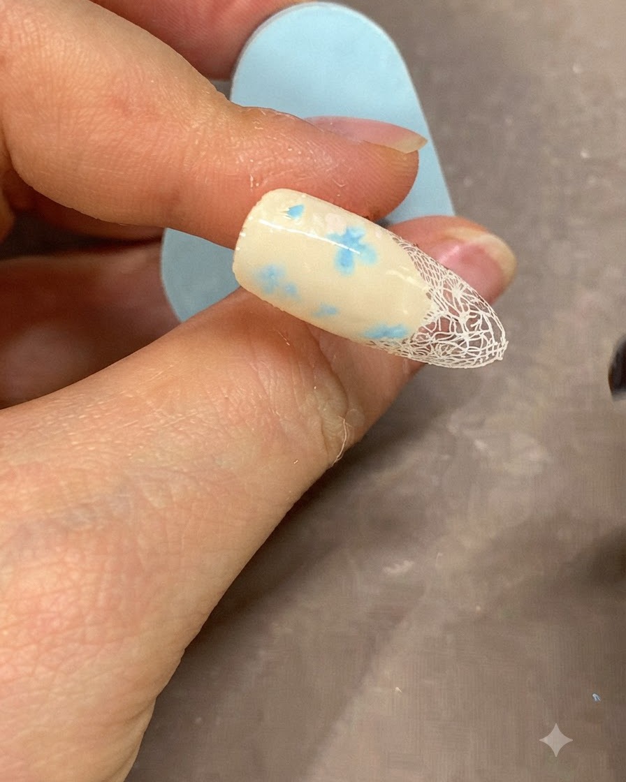 Cienki pędzelek nakładający wyrazistą białą linię żelową wzdłuż krawędzi manicure francuskiego.