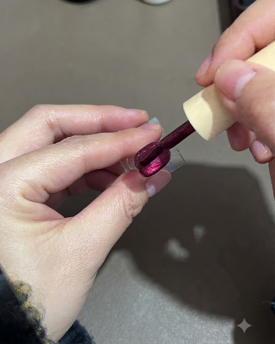 Pędzelek wygładzający drugą warstwę fioletowego lakieru cat-eye na stojaku ekspozycyjnym.