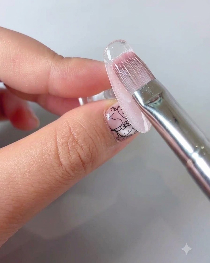 Pędzelek do manicure nakładający przezroczysty, uszczelniający top na kwiatowy wzór paznokcia.