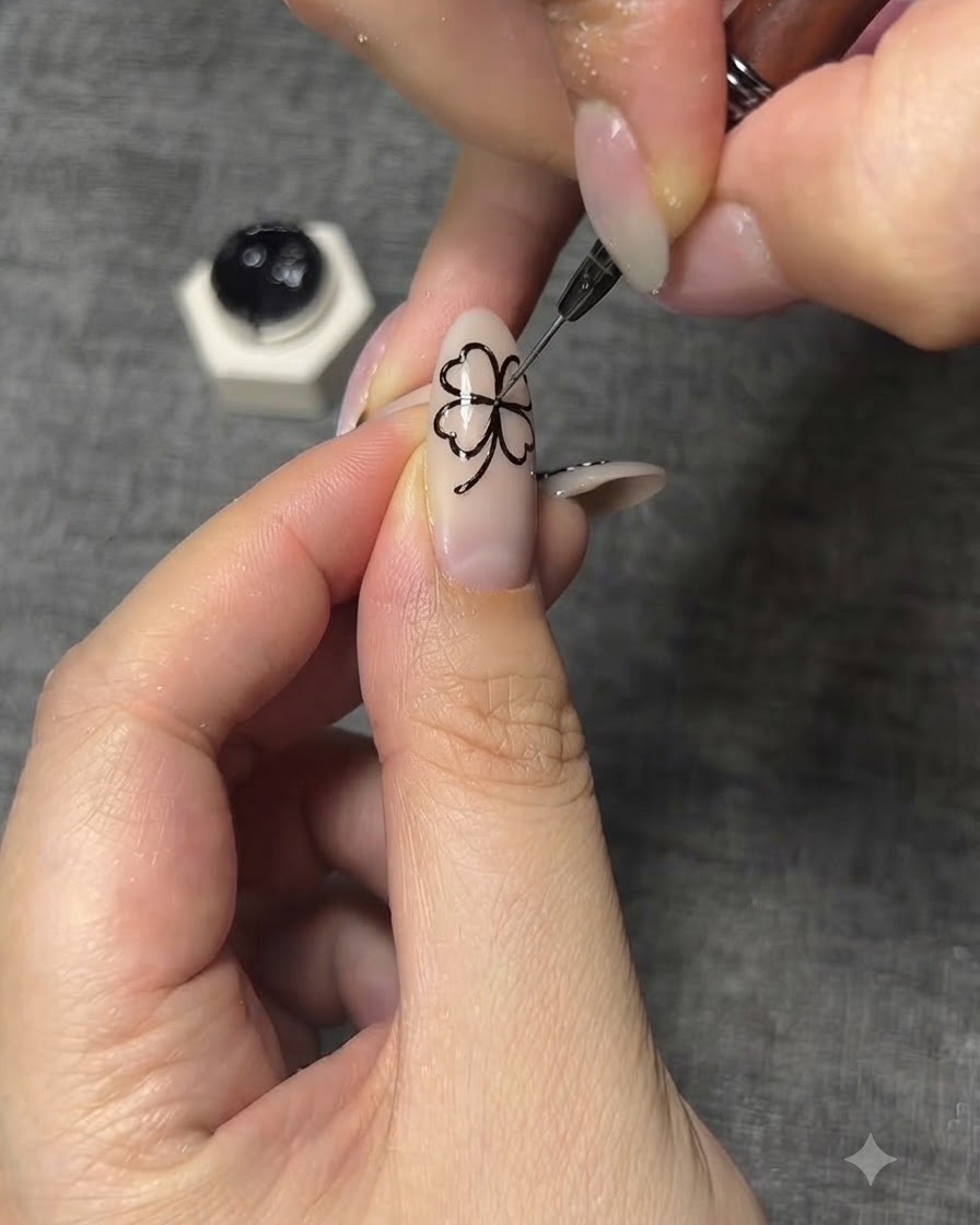 Zbliżenie na cienki pędzel do nail art malujący skomplikowane czarne detale żyłek na skrzydłach motyla.