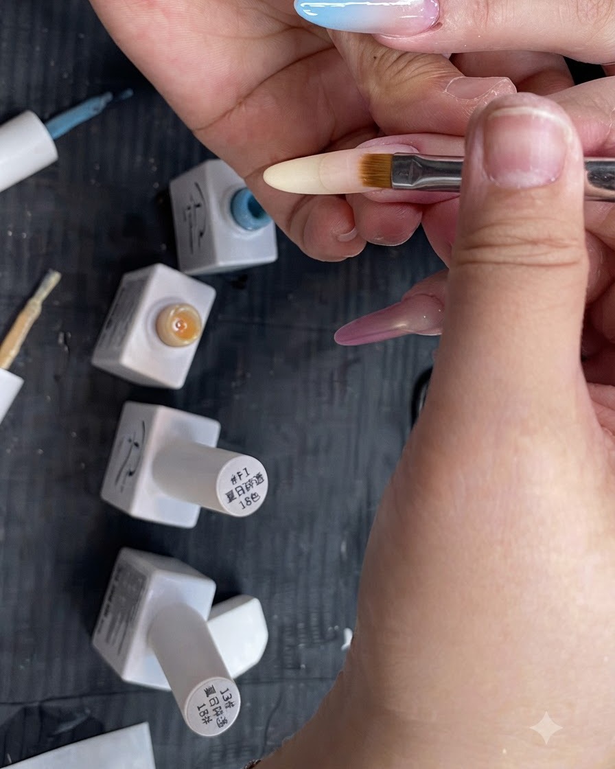 Płaski pędzelek do paznokci ombré rozcierający półprzezroczysty żółty gradient w dół na długim paznokciu o migdałowym kształcie.