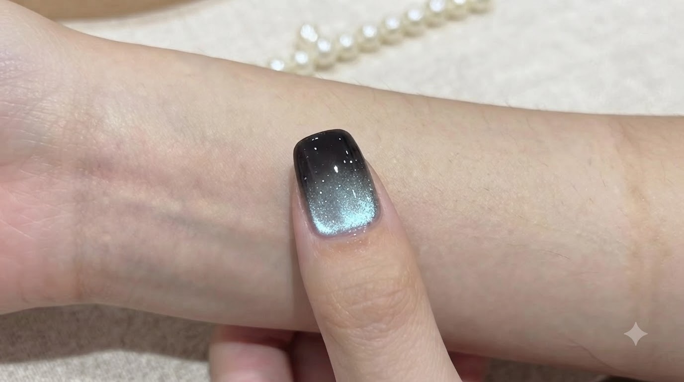 Ein fertiger Aquamarin-Gradienten-Cat-Eye-Nagel mit einer tiefschwarzen Spitze und einer schimmernden blau-silbernen magnetischen Reflexion.