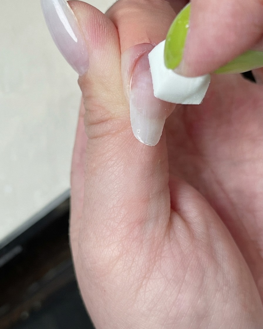 Paznokieć utwardzany pod mini lampą z poświatą białego światła.
