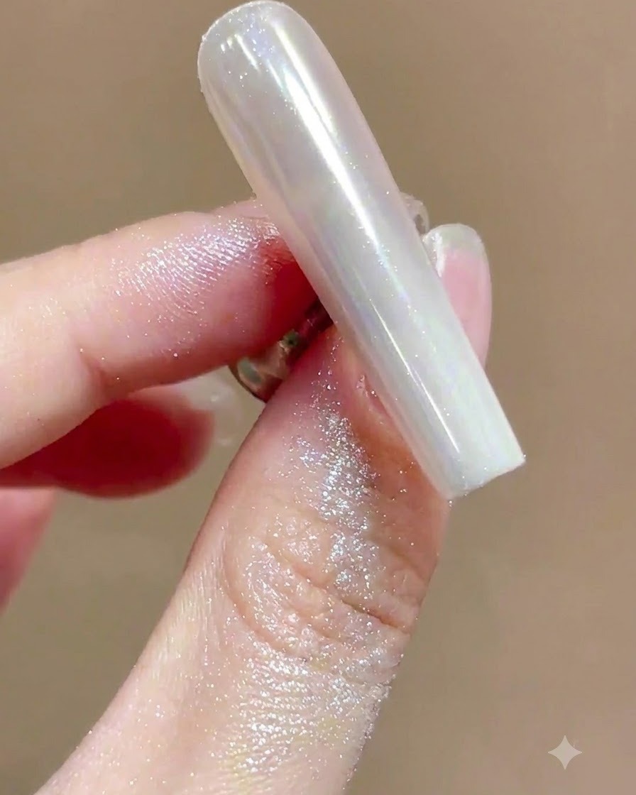 Miękki pędzelek omiatający nadmiar mieniącego się pyłku z manicure chromowego o wysokim połysku.