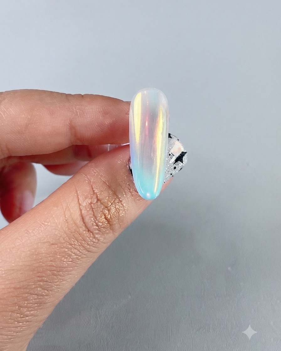 Zbliżenie wykończonego opalizującego paznokcia chromowanego aurora pokazującego żywe, wielokolorowe odbicie lustrzane.