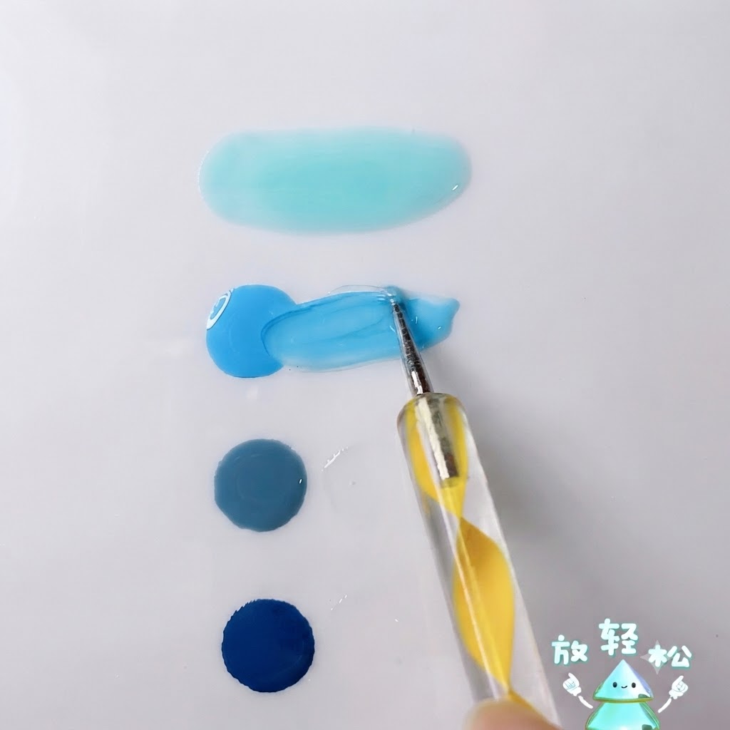 Un puntero mezclando gel azul cielo brillante con gel transparente sobre la superficie de una paleta blanca.