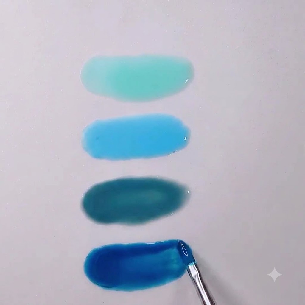 Un primer plano de un pincel de uñas alisando los bordes de una poza de gel translúcido azul Morandi profundo.